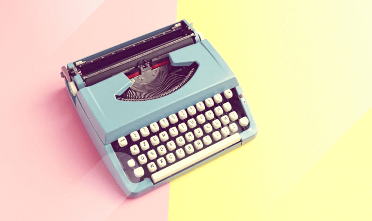 blue typewriter on pink and yellow background for ad copy blog