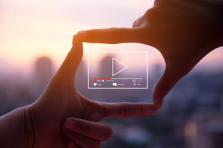 Two hands around an illustration of a video play button representing video snippets